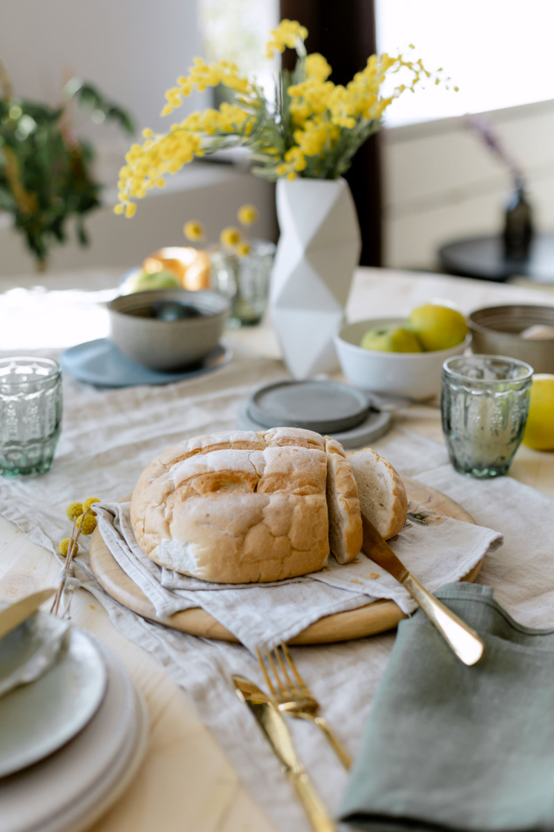 A set table with stoneware plates and linen napkins.