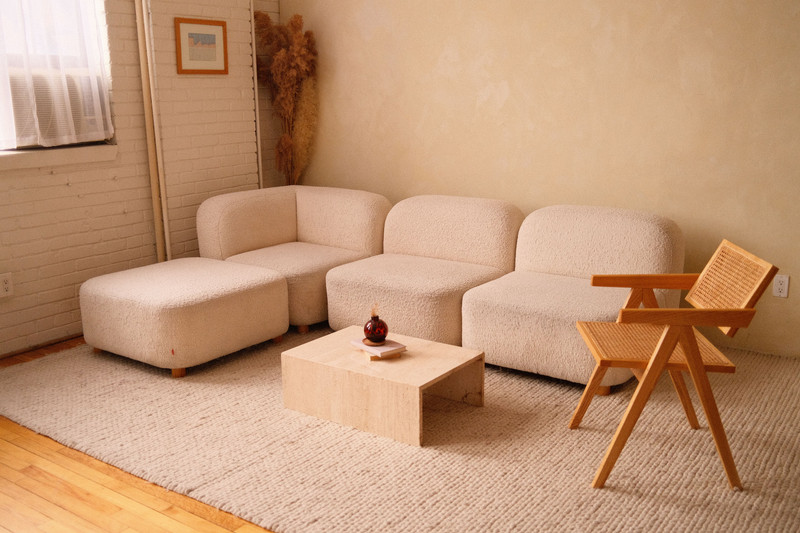 A warm cream living room with a low sofa and soft light.